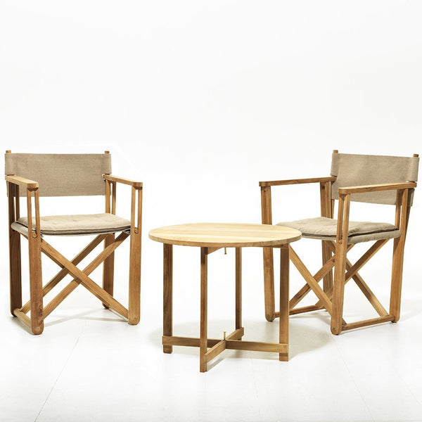 "Two beige canvas chairs with wood frames and a natural wood side table on a white background."