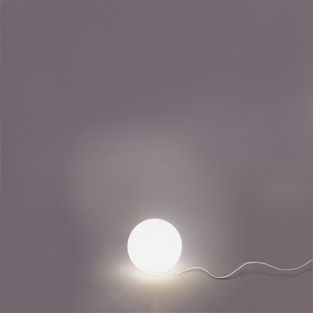 Round white lamp on a soft gray background, illuminated with a smooth, minimalistic design.