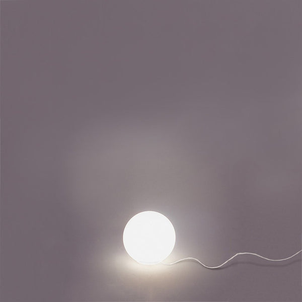 Round white lamp on a soft gray background, illuminated with a smooth, minimalistic design.
