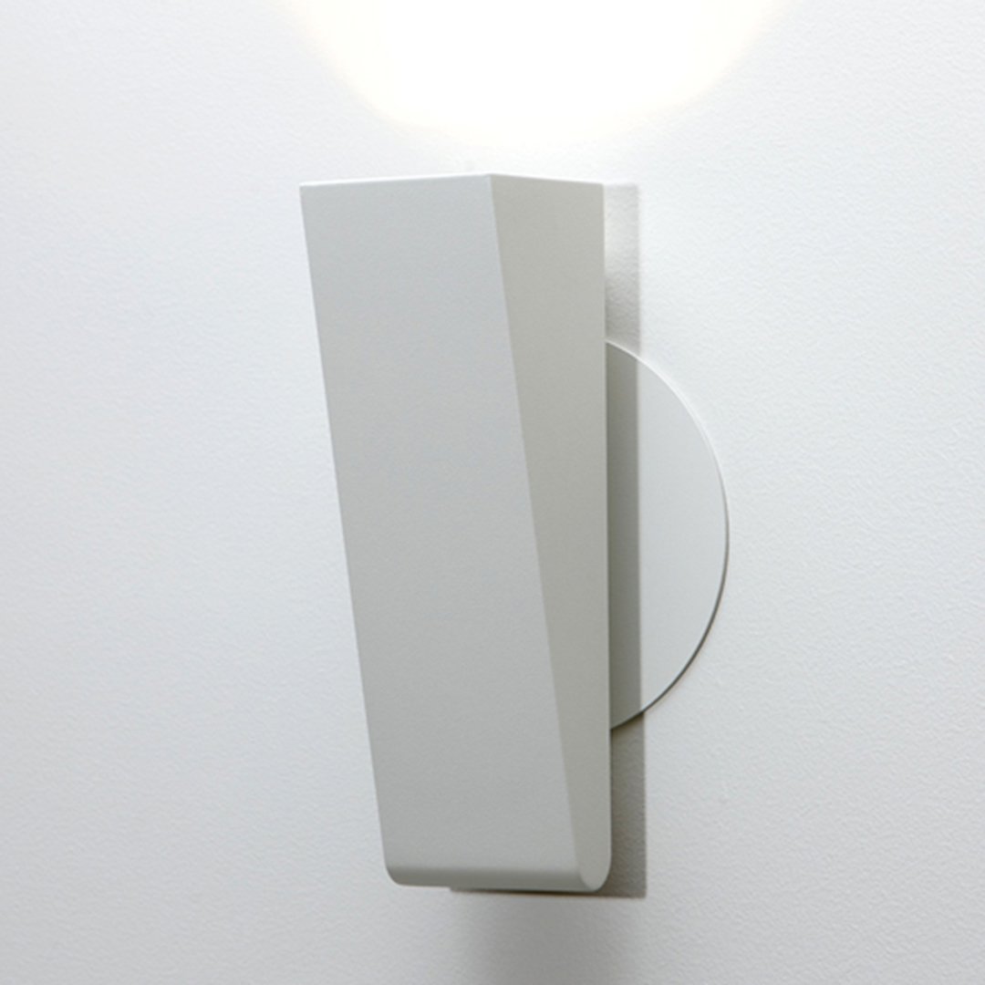 Sleek white wall sconce with a geometric design and smooth surfaces, highlighting modern minimalist decor.