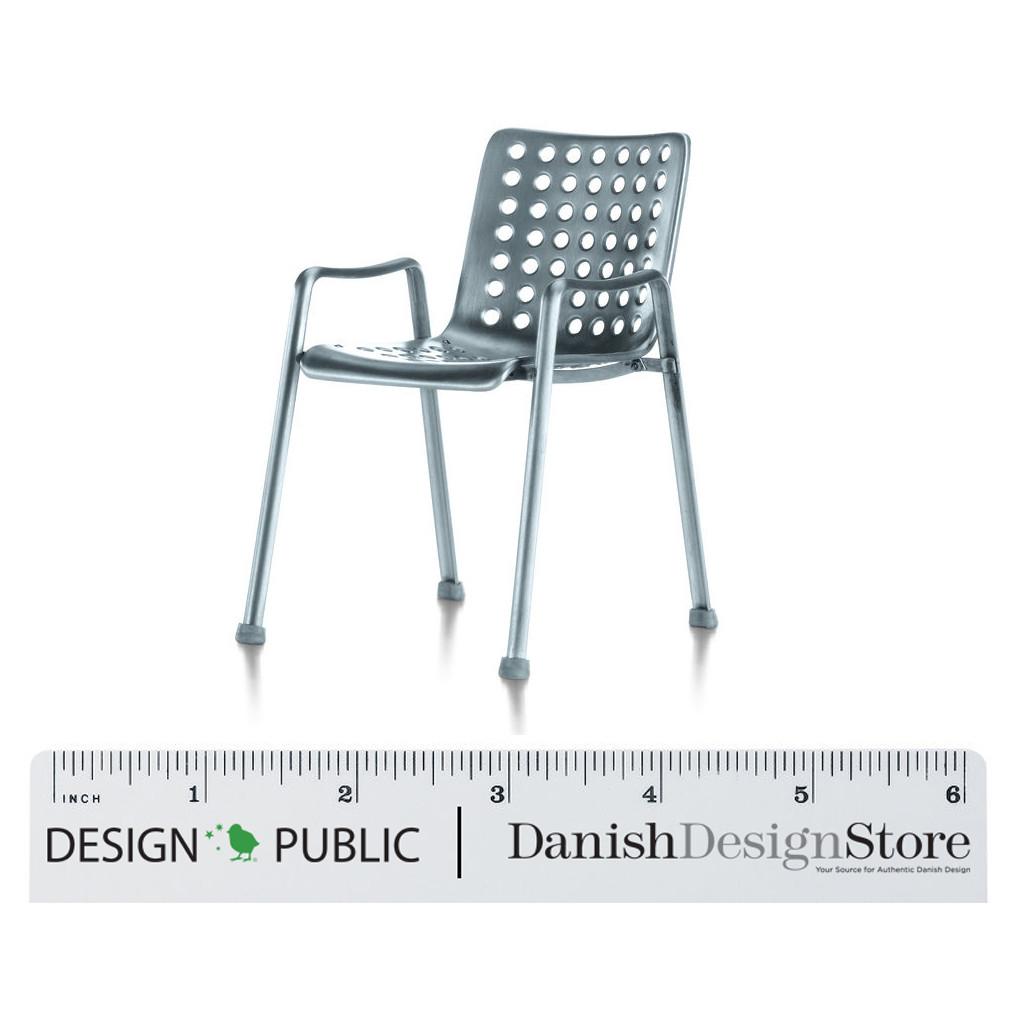 Light blue chair with a modern perforated pattern, featuring sleek metallic legs.
