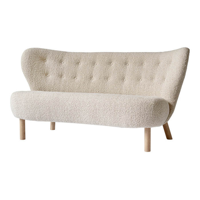 Cream-colored tufted sofa with smooth, rounded edges and light wooden legs. Soft, textured upholstery adds elegance.