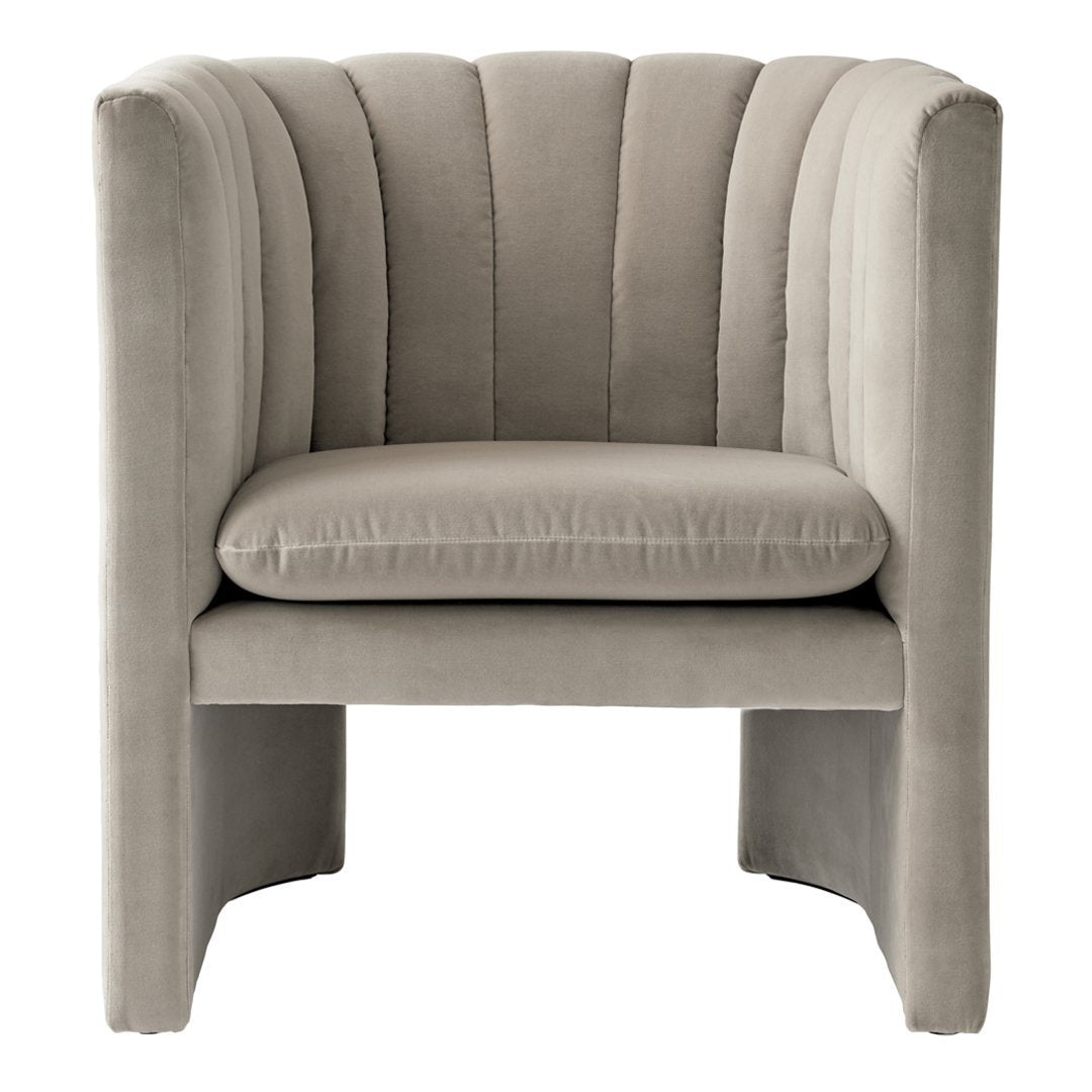 Beige velvet accent chair with vertical channel tufting and a modern, minimalist design.
