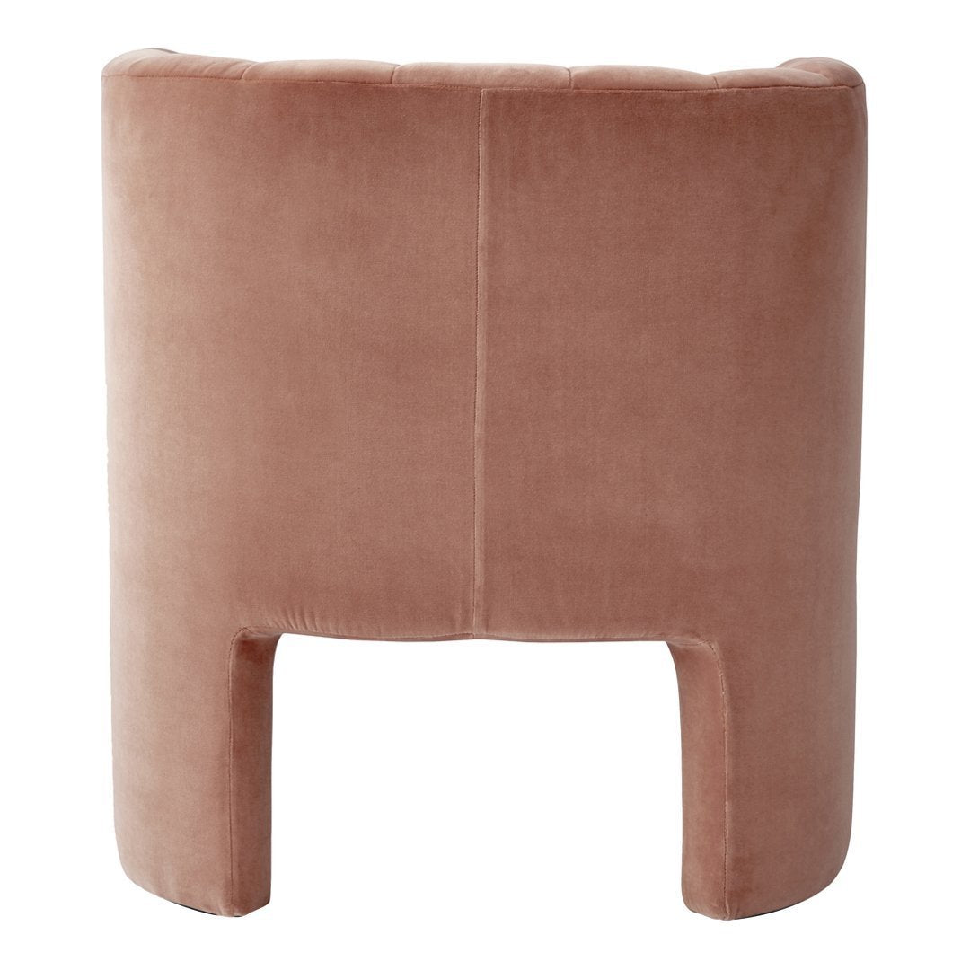 "Soft blush pink upholstered chair with a smooth velvet texture and minimalist design."