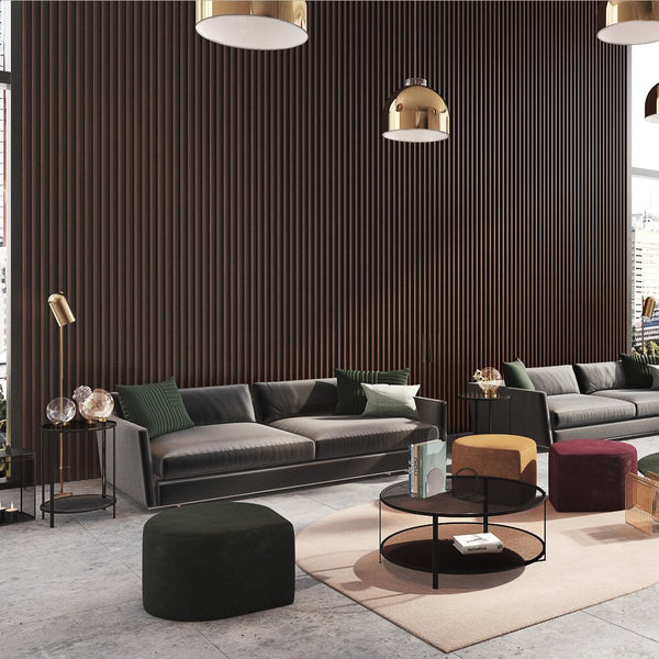 Modern living room featuring a dark wood panel wall, green, gray, and burgundy accents, with patterned poufs and decorative elements.
