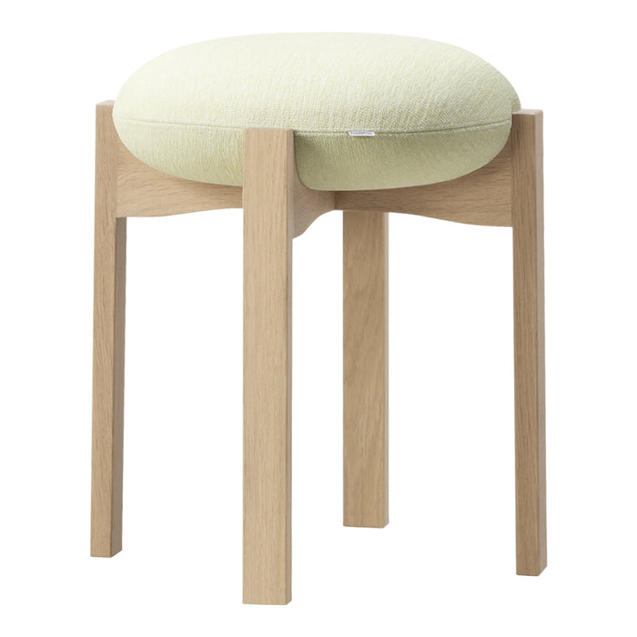 Light green cushioned stool with a smooth, rounded top and natural wood legs for a minimalist aesthetic.