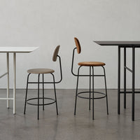 Gray and brown bar stools with sleek black legs, set against a minimalist, light gray background.