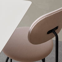 "Soft beige chair with a rounded back, paired with a sleek white table against a muted gray backdrop."