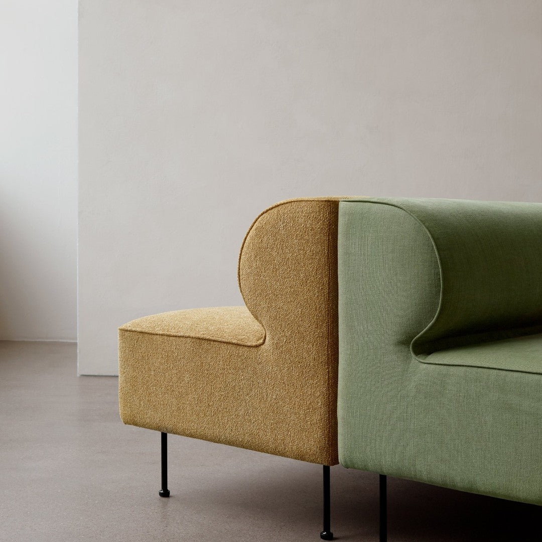 Two-tone sofa featuring a textured green and mustard yellow design with sleek black legs. Modern and stylish.