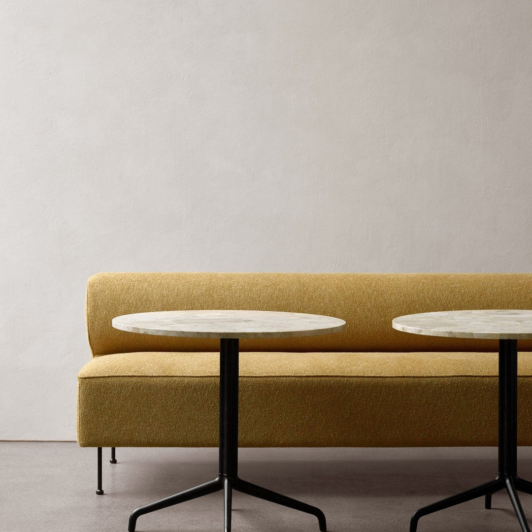 Yellow textured sofa with white marble top tables in a minimalist setting. Stylish and modern color palette.