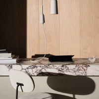 Elegant marble tabletop featuring white and dark veining patterns, complemented by a natural wood backdrop.
