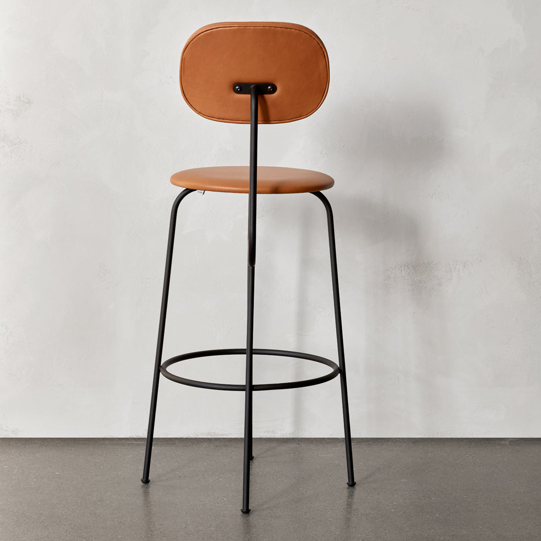 Tan leather upholstered bar stool with a sleek black metal frame and minimalistic design.