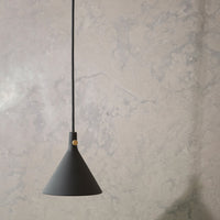 Black conical pendant lamp with a sleek matte finish, suspended against a textured gray wall.