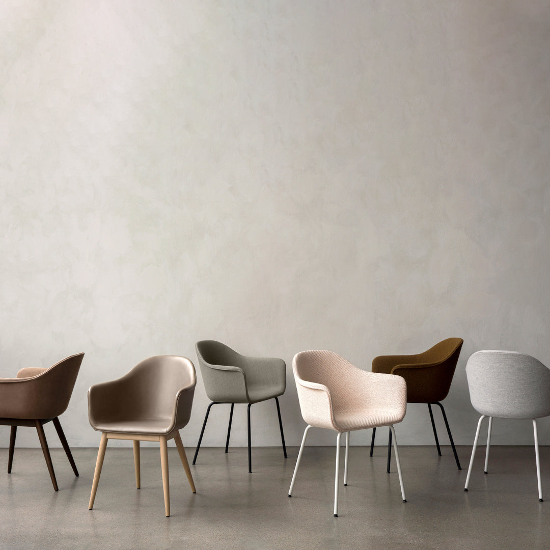 Six stylish chairs in earthy tones: brown, gray, beige, and olive green with various textures and finishes.