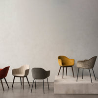 Colorful chairs in red, beige, gray, and yellow with varied patterns displayed on a minimalistic platform.