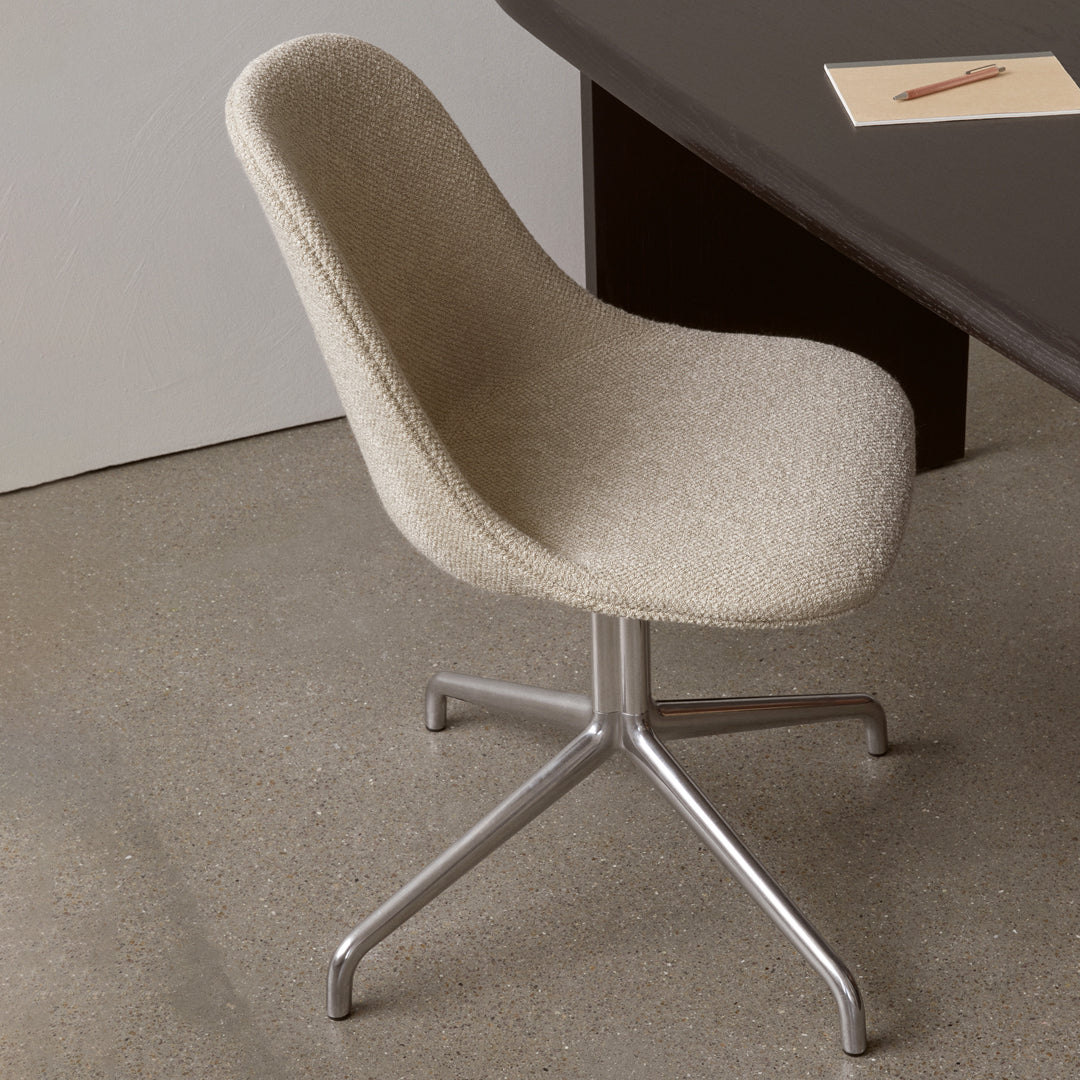 Beige textured chair with a sleek metallic base, set against a minimalistic backdrop.