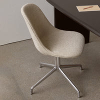 Beige textured chair with a sleek metallic base, set against a minimalistic backdrop.