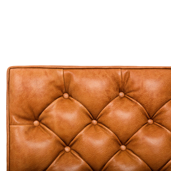 Brown tufted leather upholstery showcasing a rich, warm hue with distinct button detailing and a smooth texture.