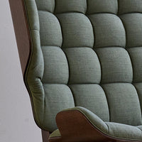 Textured green upholstery with button tufting and a wooden armrest. Modern design adds elegance to any space.