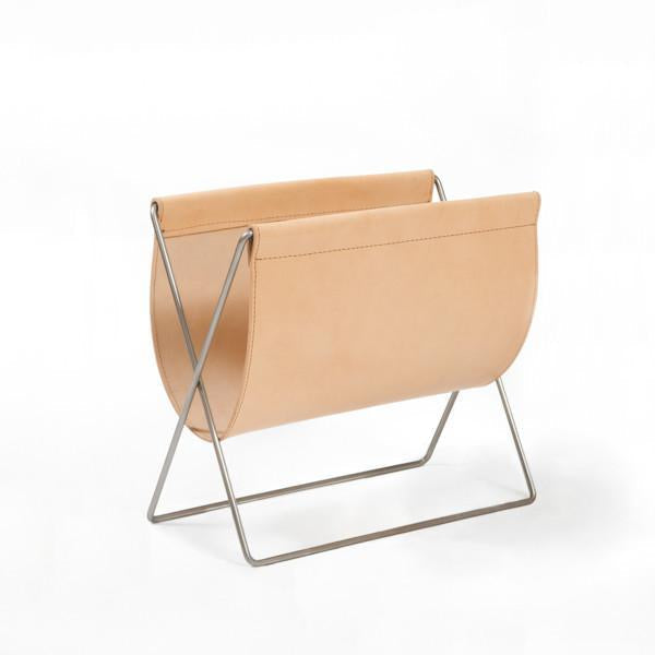 Cream leather magazine holder with a sleek stainless steel frame, showcasing minimalist design and modern aesthetics.