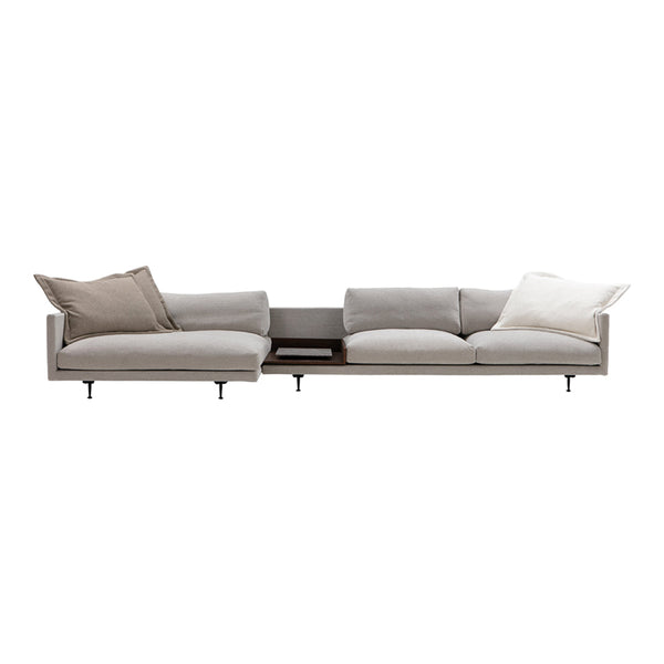 Light gray modern sofa with varied textured cushions in soft beige and cream accents.
