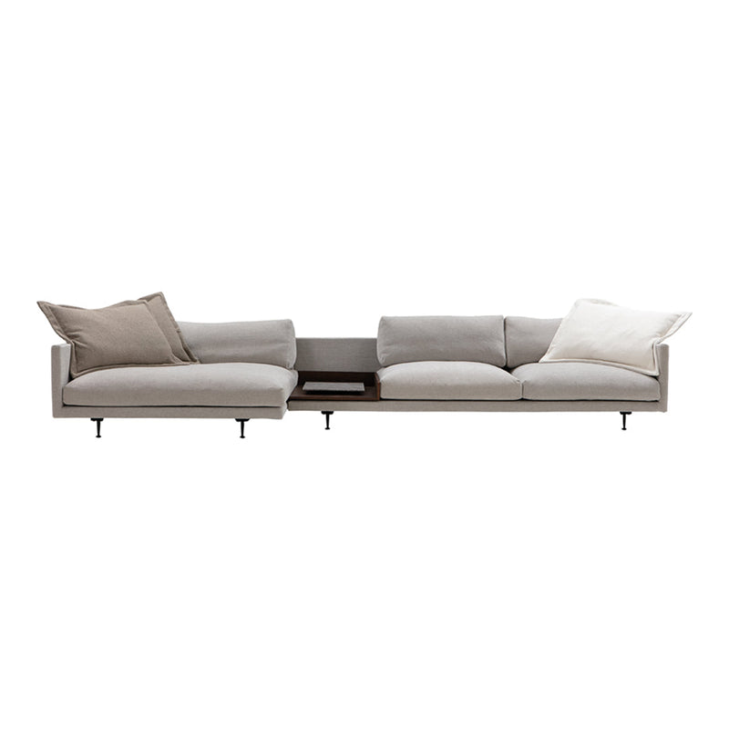 Light gray modern sofa with varied textured cushions in soft beige and cream accents.