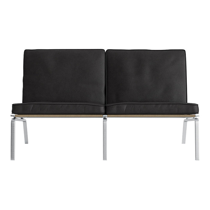 Black upholstered sofa with smooth cushions and sleek silver metal legs, showcasing a modern minimalistic design.