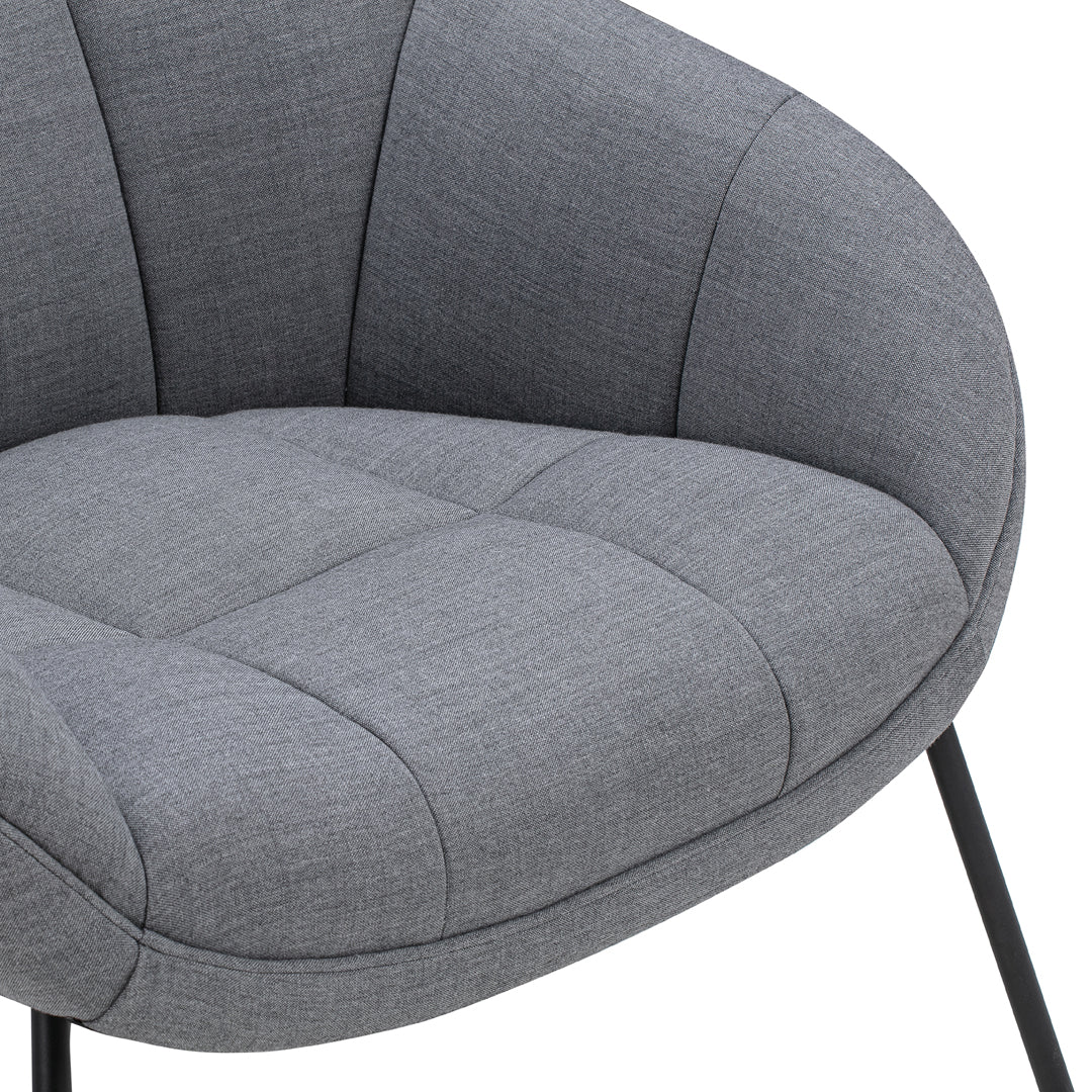 Gray upholstered chair with tufted texture and sleek, modern design; elegant pattern enhances contemporary decor.