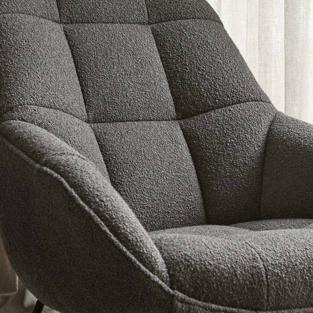 Gray textured chair with tufted upholstery, showcasing a modern, cozy pattern perfect for contemporary decor.