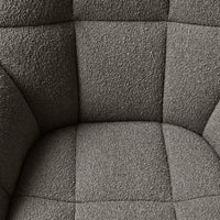 Gray textured fabric with a subtle tufted pattern on a cushioned chair. Ideal for modern decor.