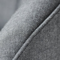 Close-up of textured gray fabric with subtle diagonal weave pattern and contrasting stitch detail.