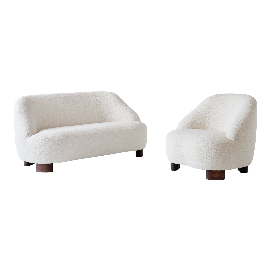 Stylish white boucle sofa and armchair set with rounded shapes and dark wooden legs. Perfect for modern decor.
