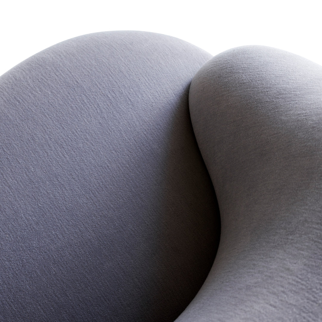 Curved gray upholstery with a subtle textured pattern, showcasing modern and sleek design elements.