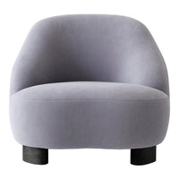 Soft gray fabric armchair with a smooth, rounded silhouette and black wooden legs. Modern minimalistic design.