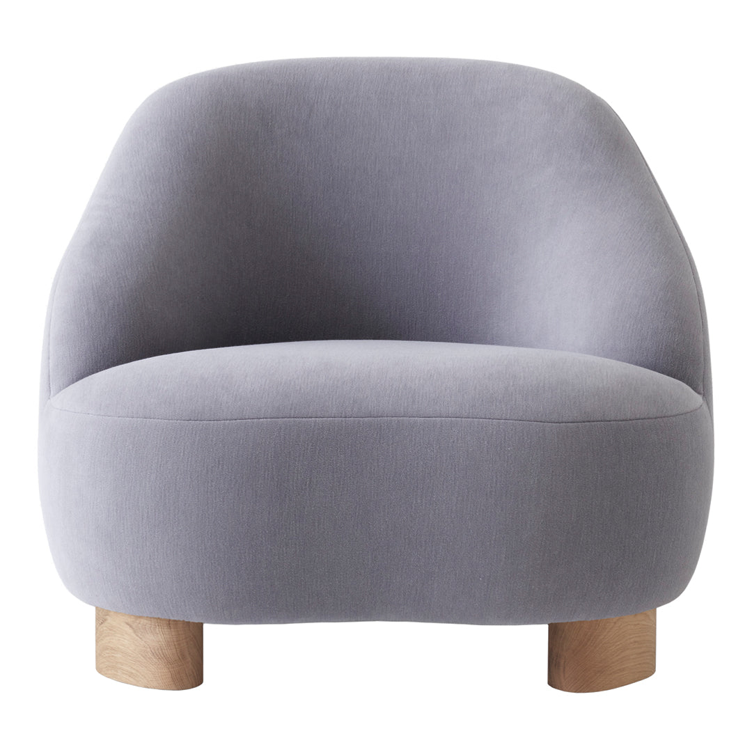 Soft gray velvet armchair with rounded shape and natural wood legs, perfect for modern decor.