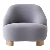 Soft gray velvet armchair with rounded shape and natural wood legs, perfect for modern decor.