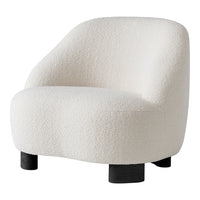 Cream textured armchair with a soft, rounded design and black wooden legs. Ideal for modern decor.