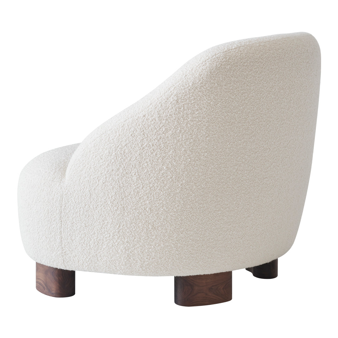 Curved cream chair with textured fabric and dark wooden legs, featuring a minimalist modern design.