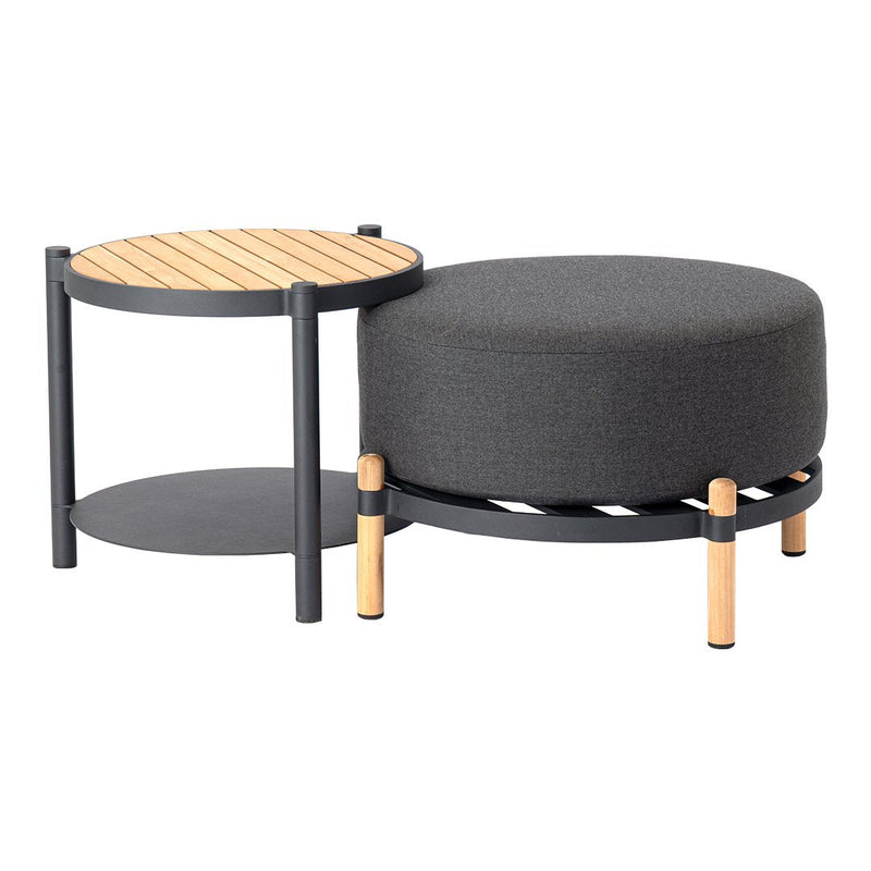 Gray upholstered ottoman with black frame and light wood accents, paired with a round wood-topped side table.