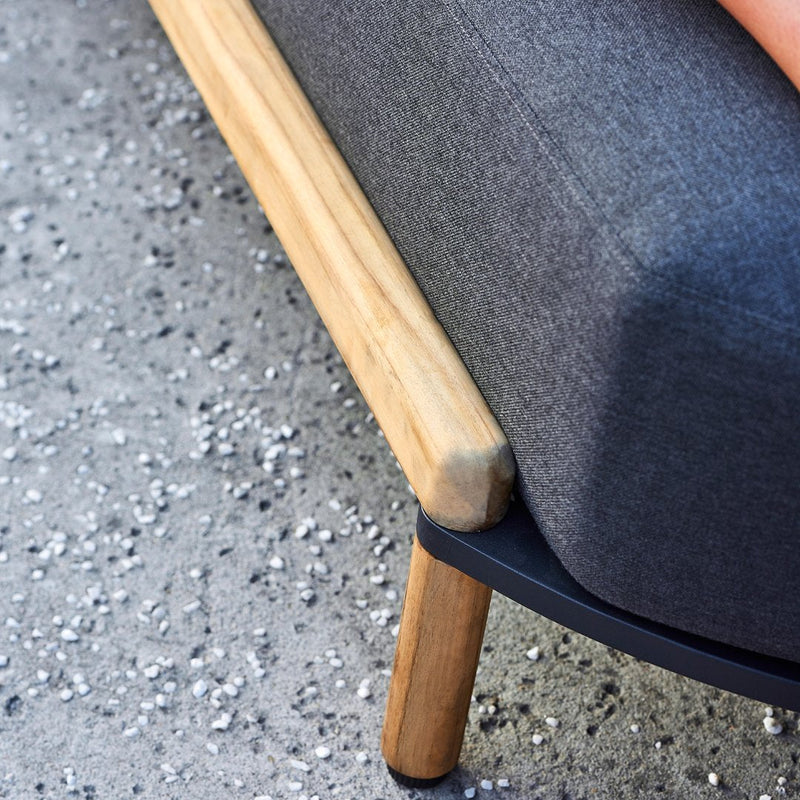 Dark gray fabric sofa with natural wood legs and a sleek black base, featuring a modern minimalist design.