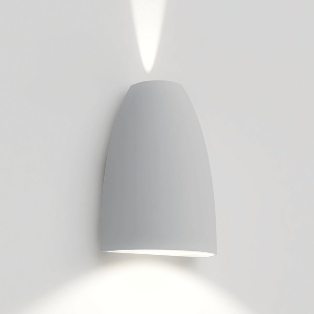 Sleek white wall lamp with a smooth, curved design and subtle light pattern. Perfect for modern home decor.