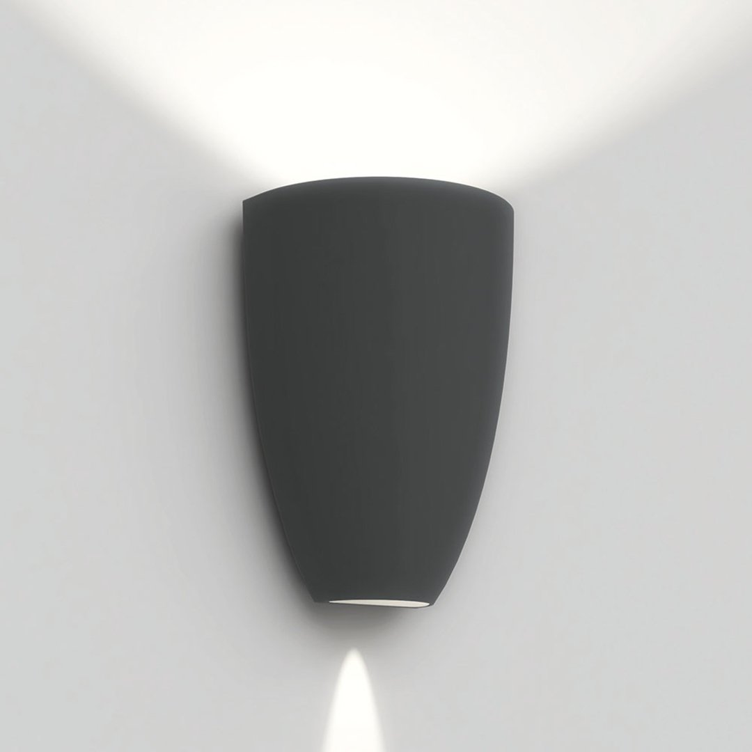 Modern black wall sconce with a smooth finish, designed to emit soft, angled light for ambient illumination.
