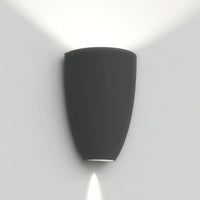 Modern black wall sconce with a smooth finish, designed to emit soft, angled light for ambient illumination.