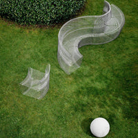Curved metallic outdoor seating in gray with a whimsical wire mesh pattern on a grassy landscape.