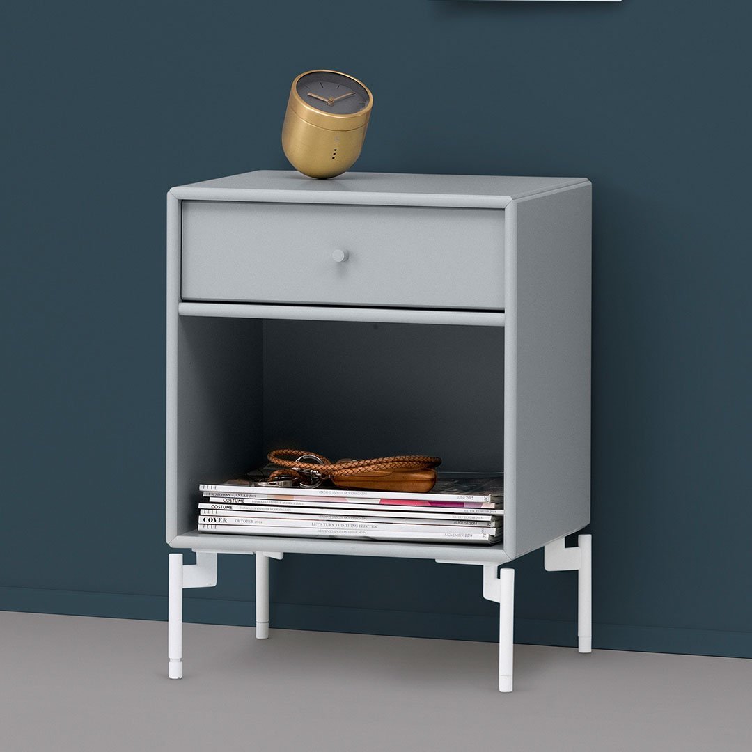Stylish light gray nightstand with a smooth surface and white legs, featuring a minimalist design.