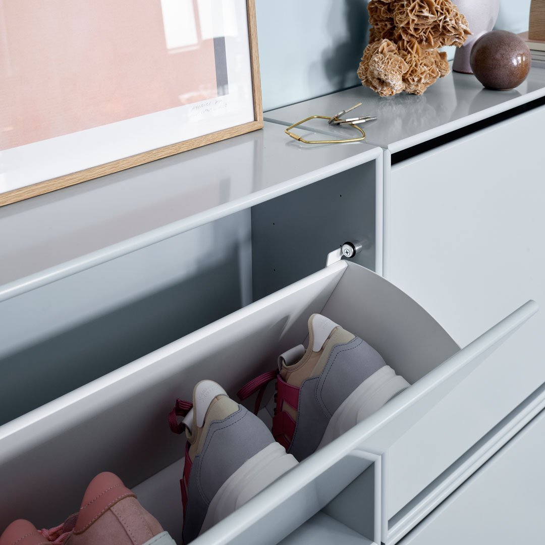 Gray shoe storage with pink and gray sneakers, featuring a sleek, modern design and minimalist aesthetic.
