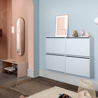 Modern light blue cabinet with sleek white lines, complemented by soft pink and earthy tones in the background decor.
