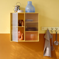 Yellow cabinet with clear and orange accents, featuring a vibrant yellow wall and a warm orange lower section.