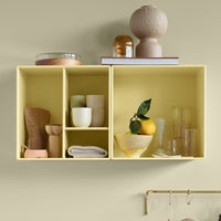 Yellow cubby shelves with assorted glassware, ceramics, and decorative items on a soft, neutral background.