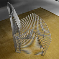 Modern wire chair in sleek silver, showcasing a geometric pattern against a warm beige carpet. Perfect for minimalist decor.